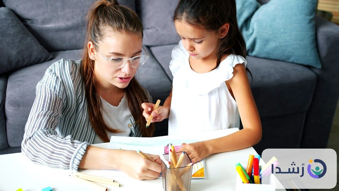 طفلة تتعلم مع معلمتها باستخدام أدوات تعليمية ملونة.