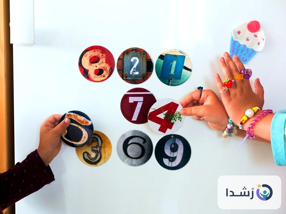 أطفال يتعلمون الأرقام باستخدام بطاقات ملونة على الثلاجة.