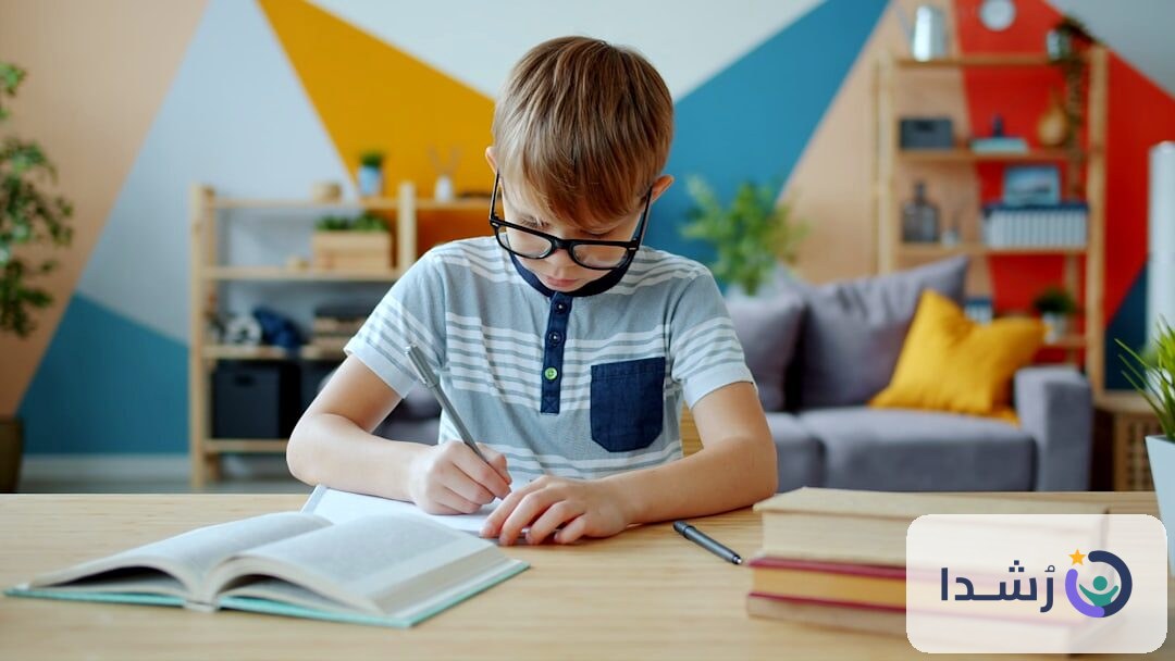 طفل يرتدي نظارات ويكتب في دفتر على طاولة تعليمية