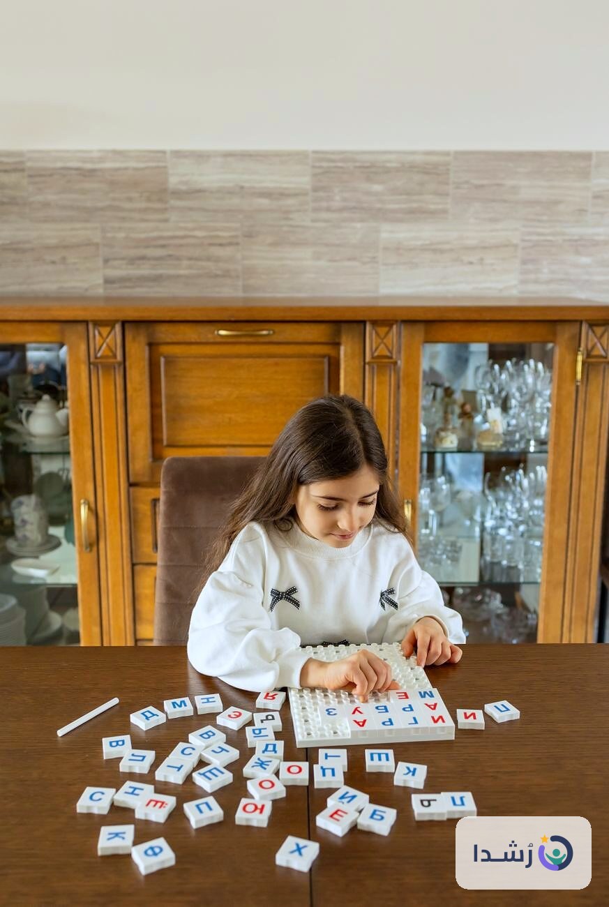 طفلة تتعلم اللغة العربية باستخدام حروف ملونة على طاولة