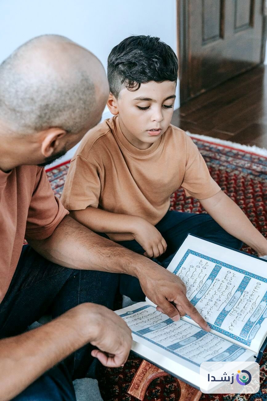 طفل يتعلم القراءة مع والده من كتاب تعليمي.