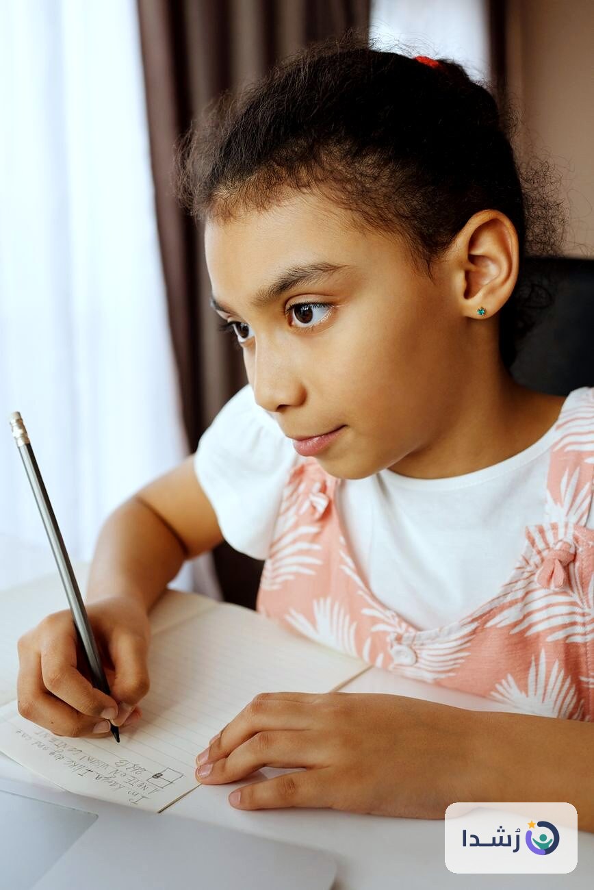 طفلة تكتب في دفترها أثناء تعلم اللغة العربية