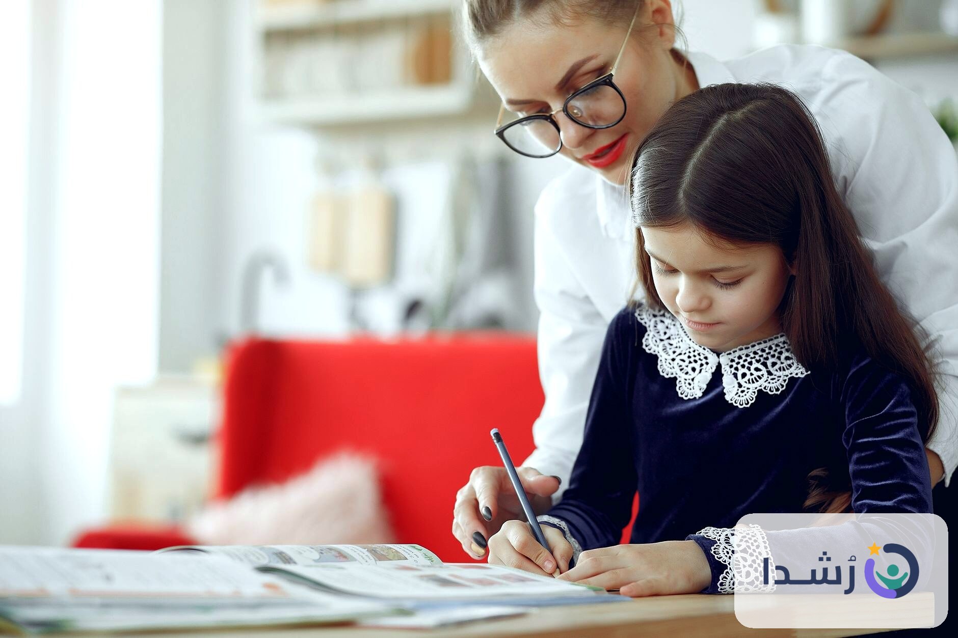 طفلة تتعلم الكتابة مع والدتها في بيئة منزلية مريحة.