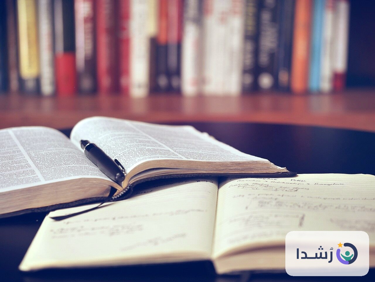كتب مفتوحة وقلم على طاولة تعليمية للأطفال.