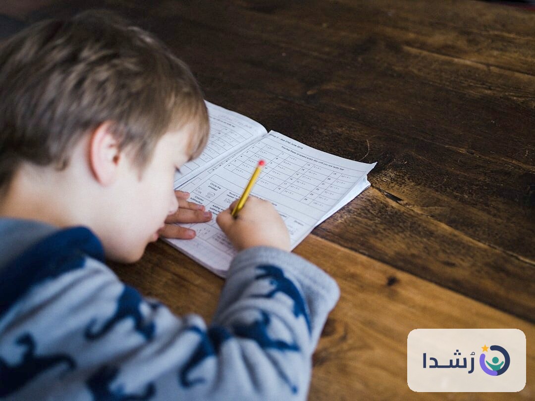 طفل يكتب في دفتر تعليم اللغة العربية