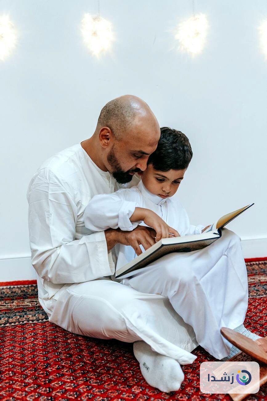 أب يعلّم ابنه القراءة من كتاب في جو هادئ.